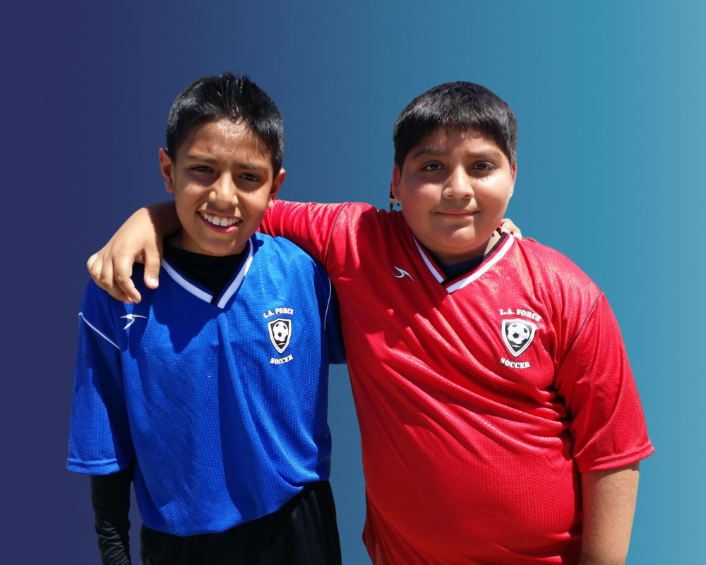 Two soccer boys hugging