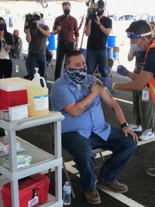 Man at a vaccine clinic getting his shot.