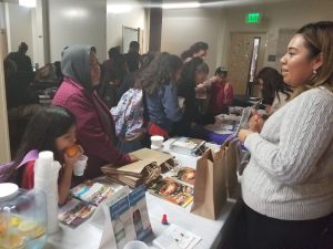 Woman providing information to families at a school.